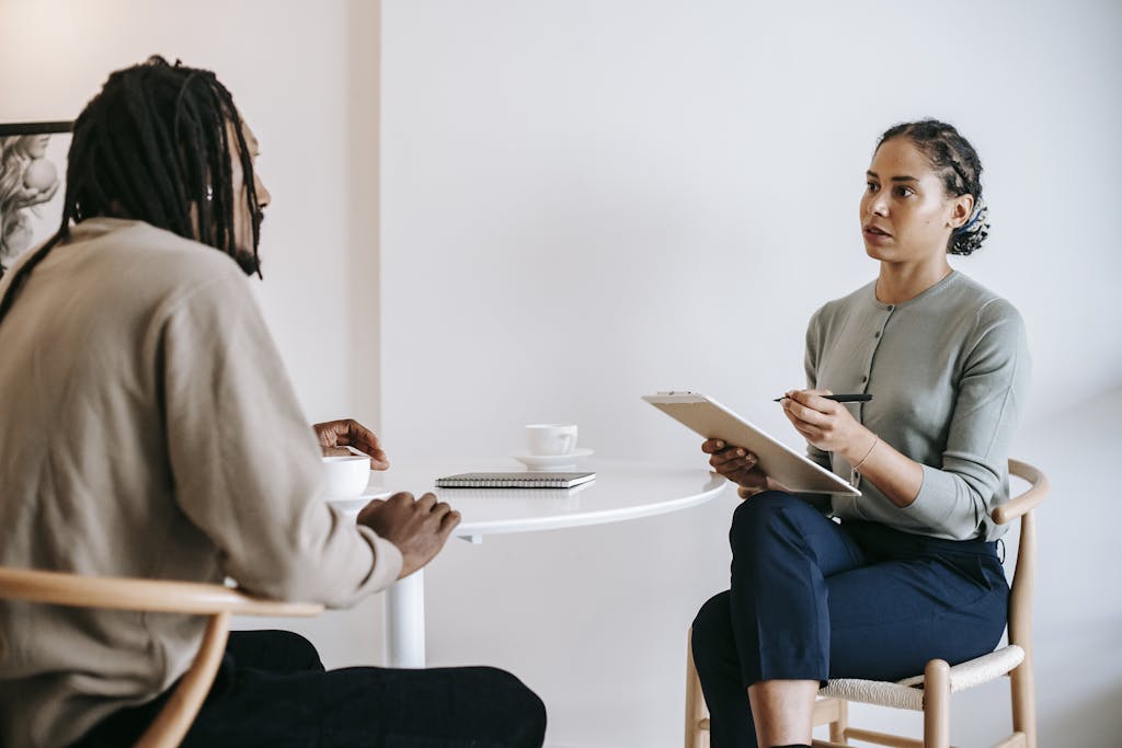 Ethnic female psychotherapist listening to black clients explanation